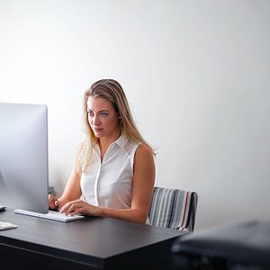 Kurs online Excel planowanie projektów i urlopów. Kobieta pracuje przy komputerze.