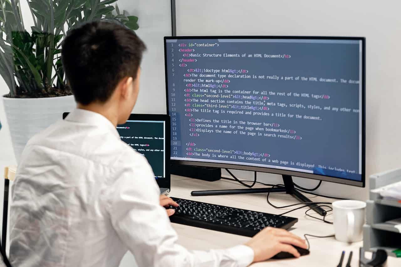 Kurs online python od podstaw. Młody mężczyzna pracuje przy komputerze.