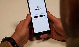 Kurs capcut - montaż filmów na telefonie. Osoba trzyma w dłoniach telefon z włączoną aplikacją CapCut.