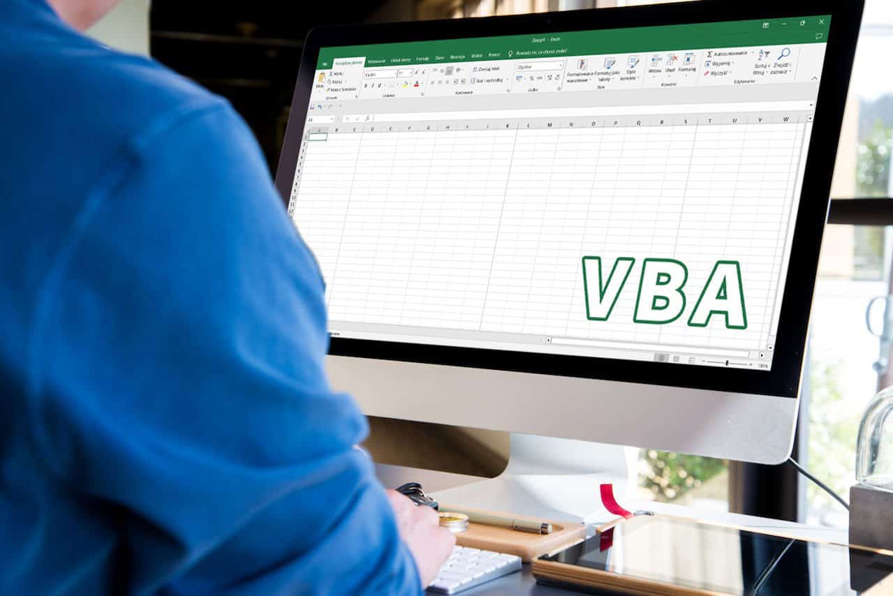 Kurs online wykorzystanie skryptów VBA w Excelu. Osoba siedzi przed monitorem. Komputer wyświetla arkusz Excela